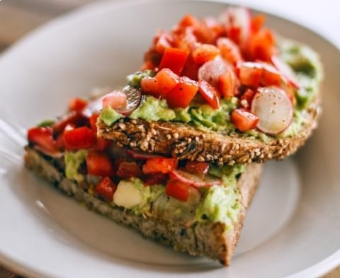 Hombre recolectando tomates en un huerto ecológico